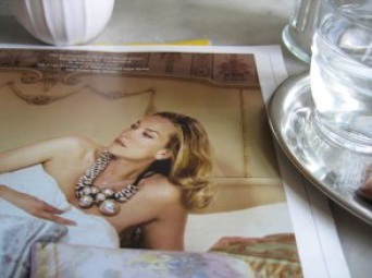 Zeitschrift mit Frauenfoto neben Kaffeegeschirr