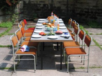 gedeckter Tisch mit je sechs Stühlen rechts und links