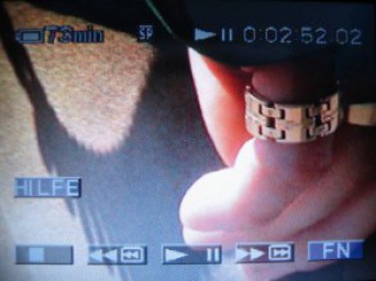 Standbild von Film: breiter Ring am kleinen Finger