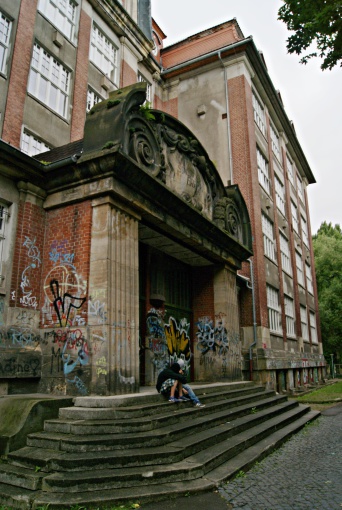 Ein mit Graffiti versehener Eingangsbereich eines großen Hauskomplexes.