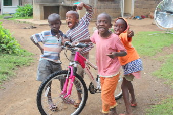 Kinder mit Fahrrad freuen sich.