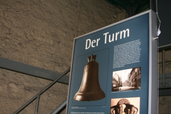 Detail einer Ausstellungstafel zum Thema "Der Turm", links davon der Treppenaufgang im Bartholomäusturm.