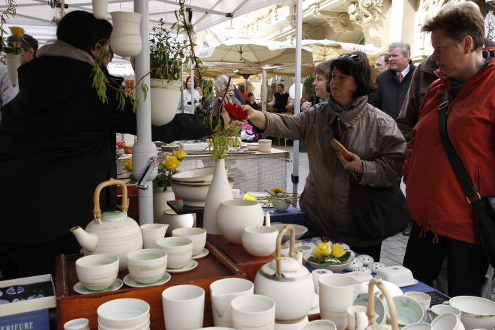 Foto: Erfurter Töpfermarkt © Stadtverwaltung Erfurt Ein Marktstand mit formschöner weißer Keramik. Rechts im Bild interessierte Besucher. Im Hintergrund ist der Oberbürgermeister Andreas Bausewein zu sehen.