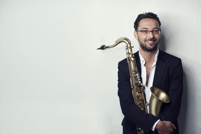 Robert Fränzel stehender Mann mit Saxophon im Arm