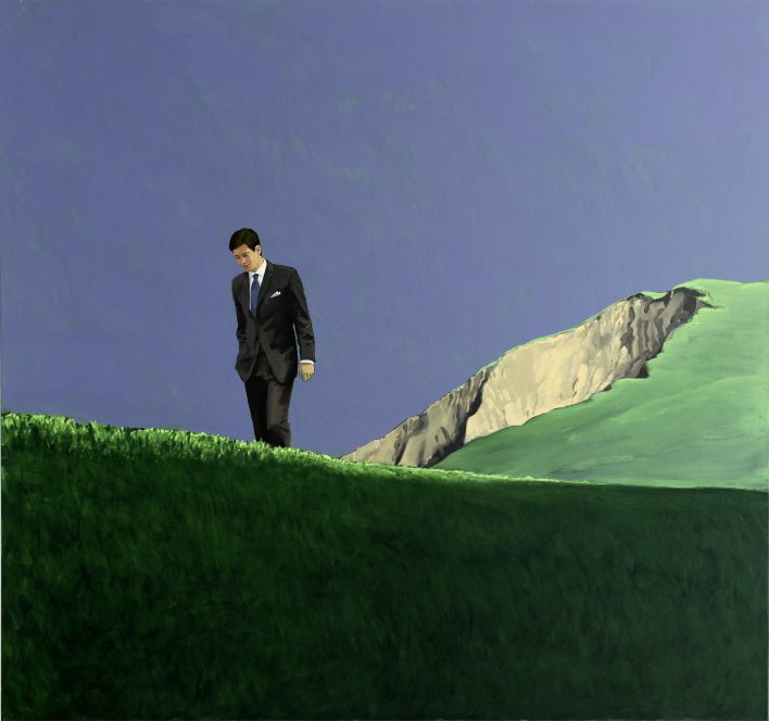 Ein Herr im schwarzen Anzug läuft über eine grüne Berglandschaft