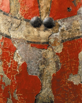 Ausschnitt aus einem durch die Zeit gezeichnetes Setzschild, Farbe (rot) zum Teil abgefallen. Zwei Nägelköpfe sehen wie "große Augen" aus.
