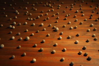 Zahlreiche aus Erde geformte Kugeln liegen auf dem Boden der Galerieetage.