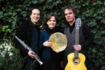 Zwei Herren und eine Dame, in der Mitte, mit Instrumenten.