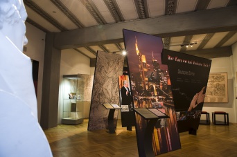 Ausstellungstafeln im Museumsraum, mittlere Tafel mit dem Abbild der Stadt New York, rechte Tafel mit Schriftzug "Der Tanz um das Goldene Kalb".