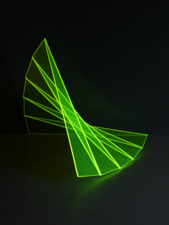 Grüne Plexiglasskulptur im schwarzen Raum.