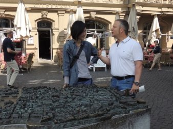 Zwei Personen stehen am Stadtmodell. Im Hintergrund die historische Altstadt.
