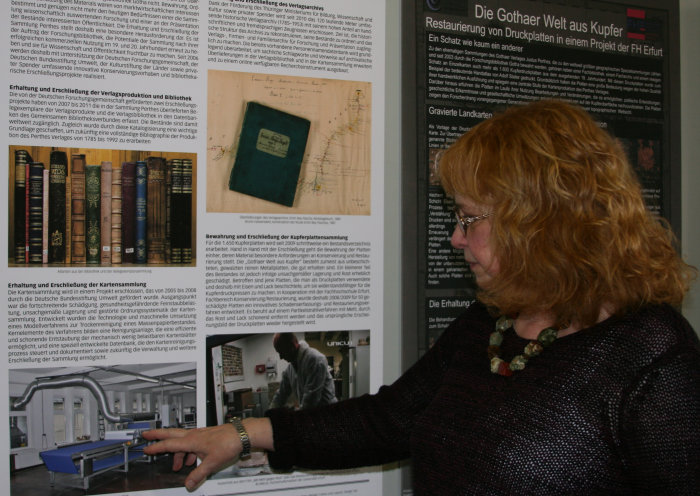 Die Gothaer Welt aus Kupfer: Karin Kosicki erklärt das Verfahren zur Erhaltung der Druckplatten Eine Dame vor einer Ausstellungstafel.