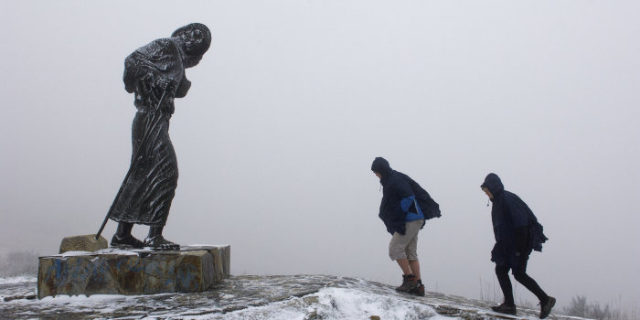 Zwei Pilger in winterlicher Landschaft auf dem Wege zu einer Pilger-Skulptur