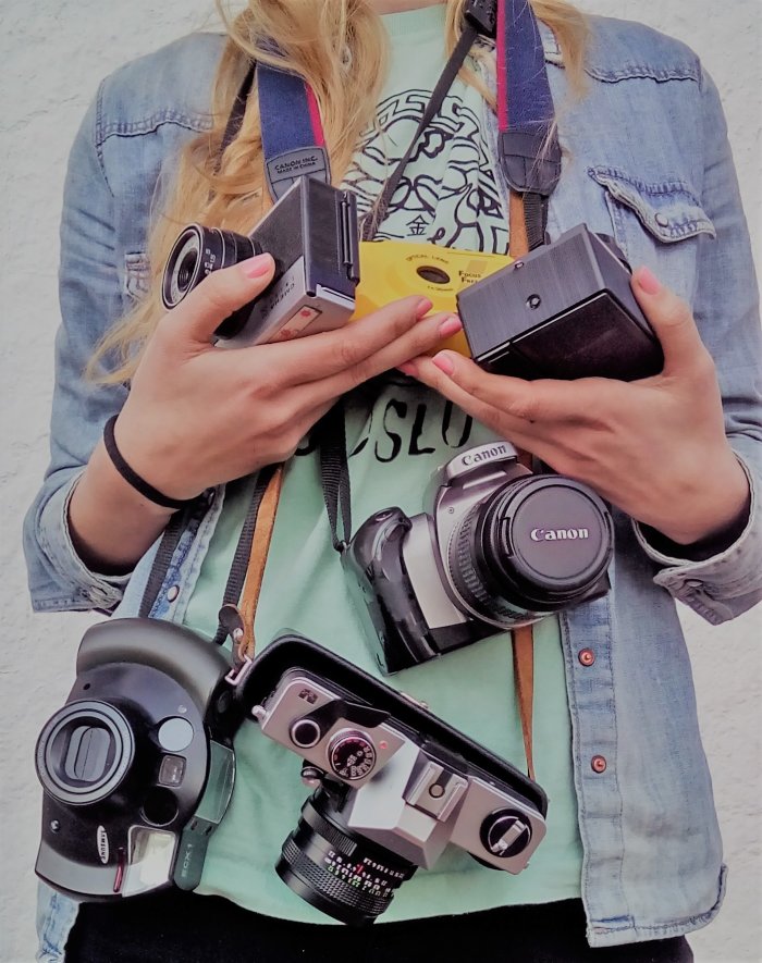 Eine Frau trägt mehrere Kameras um ihren Hals