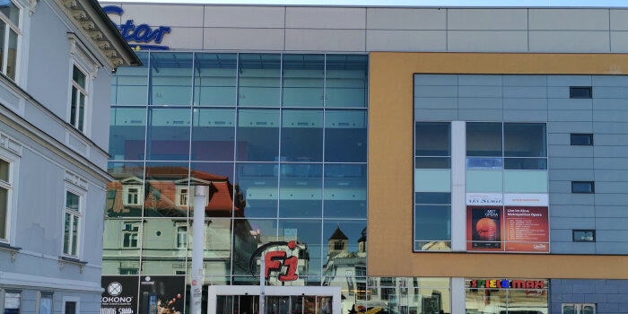 das moderne Gebäude mit dem roten Namen F1 über dem Eingang und dem goldenen Spatz daneben, Domizil vom Cine Star