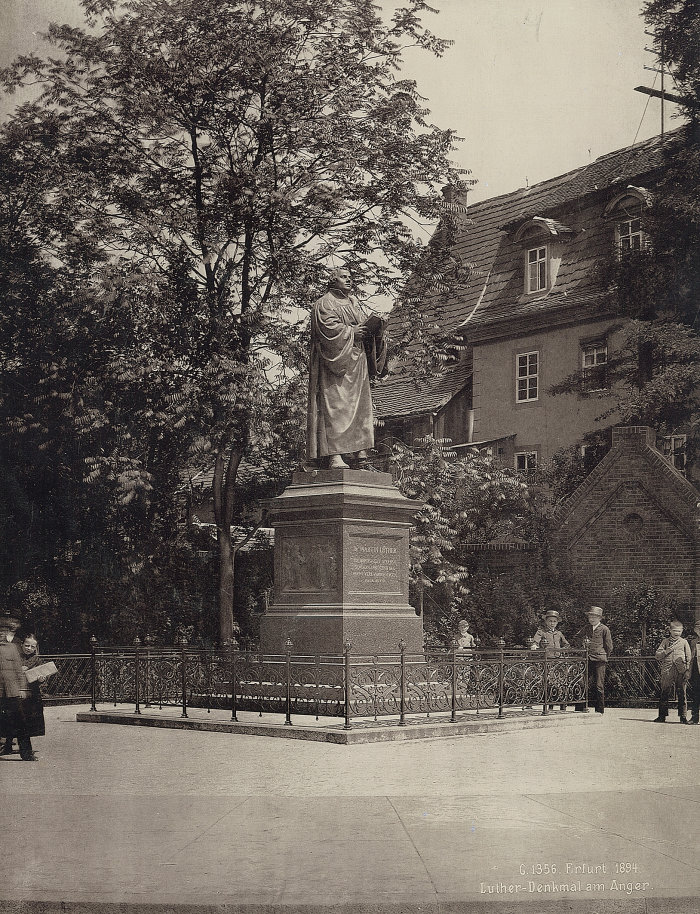 Lutherdenkmal auf dem Erfurter Anger. Feierlich enthüllt wurde das Denkmal, welches der Berliner Bildhauer, Prof. Fritz Schaper, Mitglied der Akademie der Künste, geschaffen hatte, am 30. Oktober 1889. Hier eine Aufnahme aus dem Jahre 1894 Denkmal auf Denkmalsockel, eingezäunt. Am Bildrand spielende Kinder.