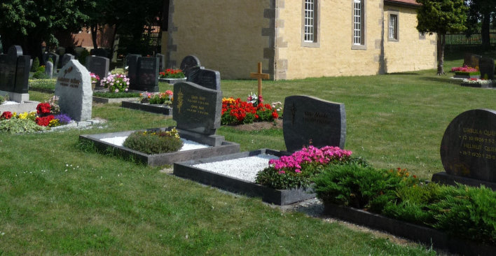 Kirche des Friedhofs in Urbich, im Vordergrund Gräber
