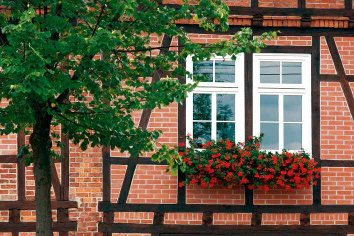 Fachwerkgebäude mit Blumenschmuck an Fensterkasten