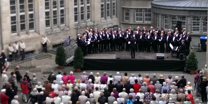 Chorkonzert im Rathausinnenhof Chor und Zuschauer in einem Gebäude umfassenden Hof