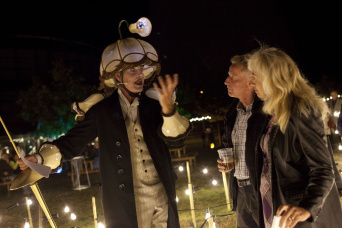 Theater Magica Lampenmann In einer Installation aus Lichtern steht der Lampenmann und spricht mit Besuchern. Die Besonderheit seines Kostüms ist der Lampenschirm auf seinem Kopf, der zudem noch von einer kleinen Leuchte gekrönt wird.
