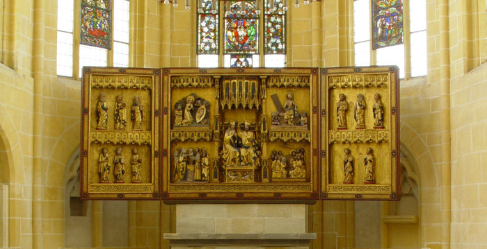Foto: Doppelflügelaltar von 1446 in der Barfüßerkirche © Angermuseum Erfurt Ein Altar in einem Kirchenraum, davor ein Taufbecken.