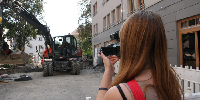 Weibliche Person fotografiert eine Baustelle