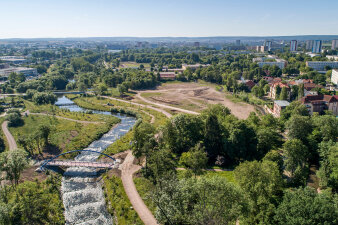 Luftaufnahme einer im Bau befindlichen Parklandschaft an einem Fluss