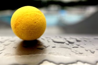 Darstellung eines Tennisballs auf einer wasserüberzogenen Platte