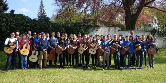 Die Mädchen und Jungen des Jugendgitarrenensembles mit ihren Instrumenten während einer Probenpause in Ulm