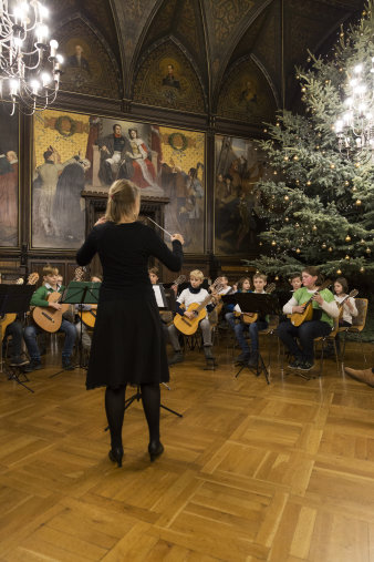 Kinderzupforchester musiziert im Rathausfestsaal vor Weihnachtsbaum