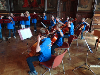 Das Kinderstreichorchester musiziert im Rathausfestsaal Kinder mit Streichinstrumenten musizieren im Rathausfestsaal