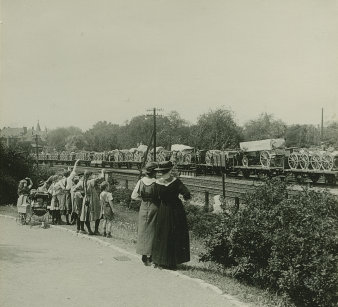Frauen und Kinder winken einem Zug zu