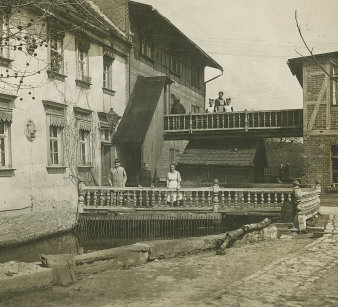 Altes Foto mit einer Mühle, neben der Menschen stehen