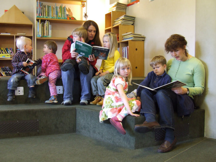 Vorlesefamilie Frauen lesen Kindern aus Büchern vor
