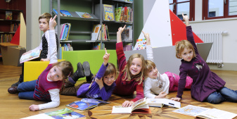 Eine Gruppe Kinder freut sich über ihre Lektüre.