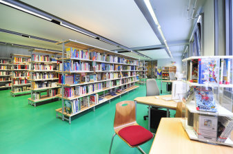 Innenansicht der Bibliothek Südpark. Blick auf Bücherregale und Ausleihtheke.