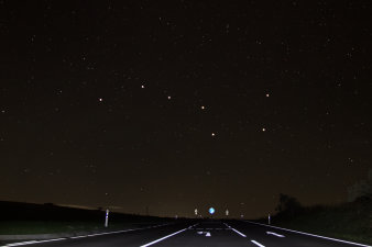 Foto: Orientierung am Sternenhimmel © Stadtverwaltung Erfurt/Grit Kästner Die Landstraße Richtung Wasserkuppe/Rhön im Vordergrund. Im oberen Teil des Bildes der nächtliche Sternenhimmel.