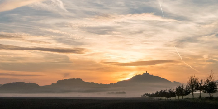 Foto: VHS-Kurs: Thüringens Geschichte © Stadtverwaltung Erfurt/Grit Kästner Landschaftsaufnahme unterhalb der Wachsenburg/Thüringen zu einem Sonnenaufgang im Nebel.