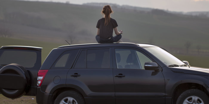 Foto: Autogenes Training © Stadtverwaltung Erfurt / Grit Kästner Mädchen in entspannter Haltung auf einem schwarzen Autodach im Sonnenuntergang sitzend.