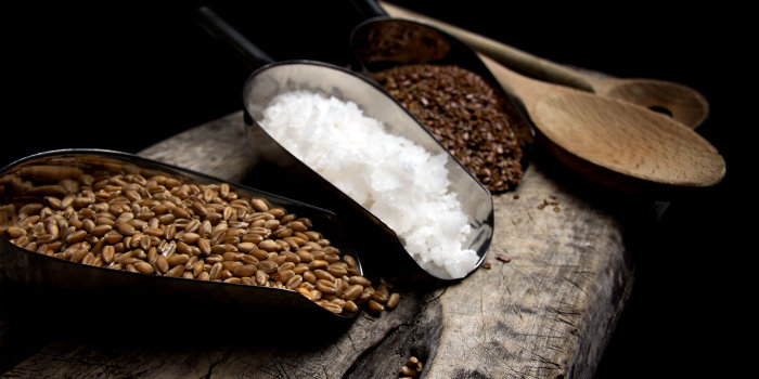 Foto: Kochkurs: Kochen mit Getreide © Stadtverwaltung Erfurt/Grit Kästner Auf einem Holzbrett liegen Küchenschübe mit Weizenkörner, Leinsamen und Fleur de Sel.