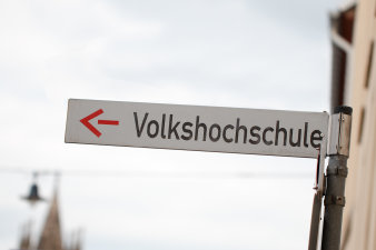 Straßenschild mit dem Hinweis, wo die Volkshochschule Erfurt zu finden ist