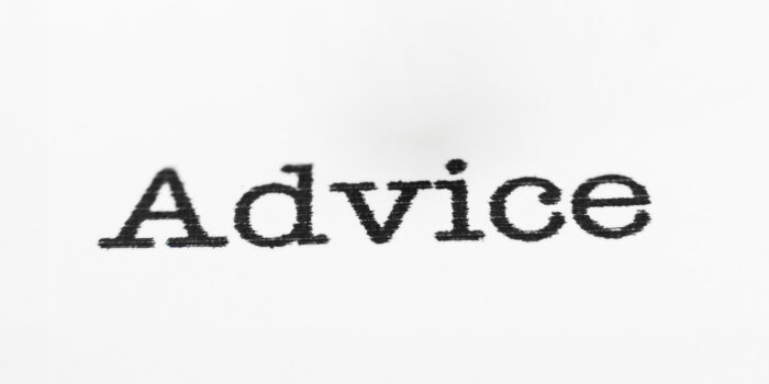 Das Wort "Advice" - "Beratung" mit Schreibmaschine geschrieben, auf weißem Papier.