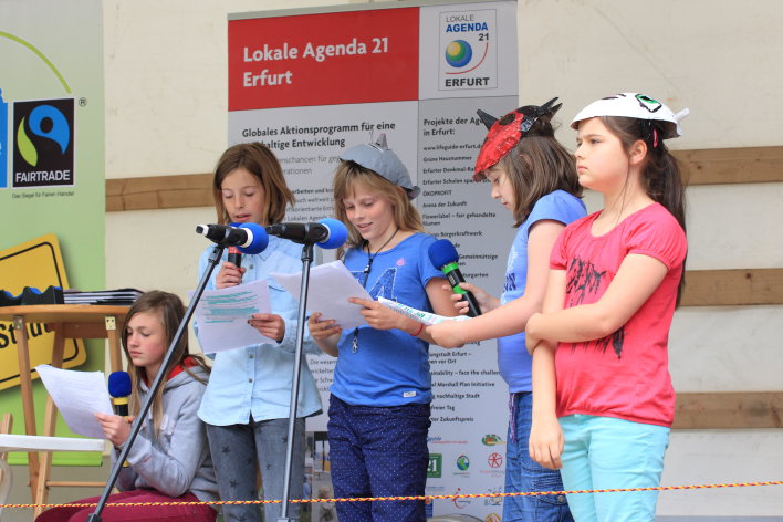 Das Foto zeigt 5 Schülerinnen der Grundschule "Am kleinen Herrenberg" bei der Präsentation des lehrreichen Stückes "Das Teufelchen im Müll".