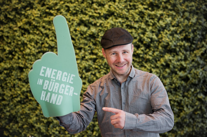 Energie in Bürgerhand Person mit Schaumstoffhandschuh