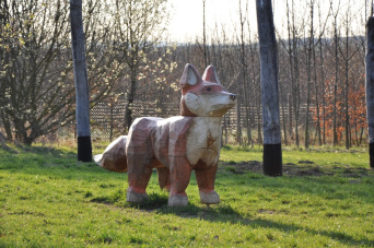 Das Foto zeigt die Holzskulptur eines Fuchses. Diese Skulptur bildet das Maskotchen der Bildungseinrichtung.