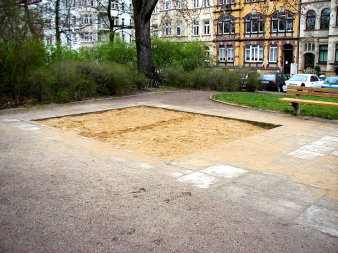 quadratische eingefasste Fläche mit Sand