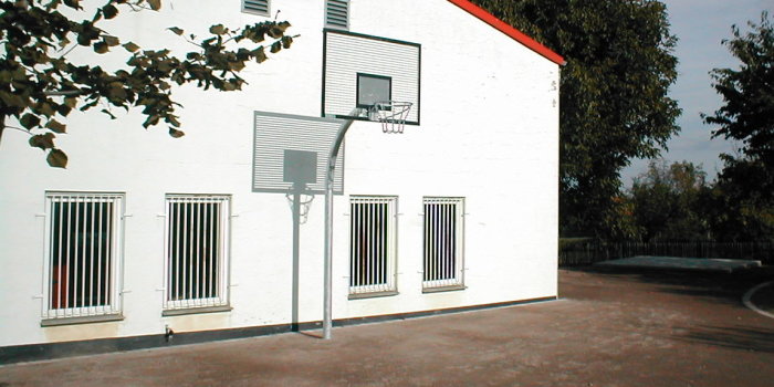 Basketballkorb mit Ständer vor einem Haus