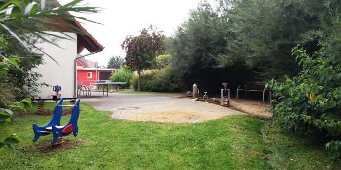 Foto: Spielplatz Brunnenstraße: Sandmulde, Federtier, Federwippe und Wasserspiel © Stadtverwaltung Erfurt kleine Sandmulde, blaues Federtier in Form eines Delphins, blau-rote Federwippe in Form eines Hundes und kleiner Wasserlauf mit verschiedenen Wasserspielen