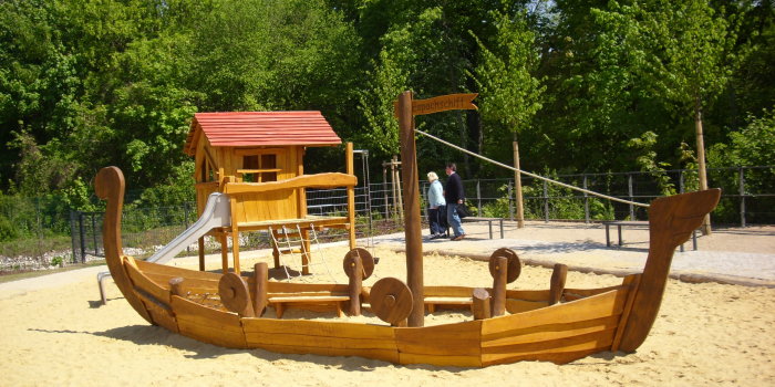 große Sandfläche mit großem Spielschiff aus Holz