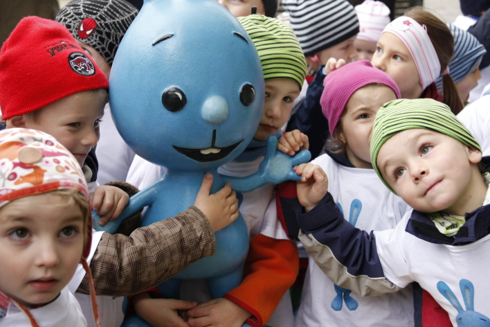 Kindergatenkinder umringen das Kikaninchen, eine blaue Kaninchenfigur aus der Vorschulwelt des Kinderkanals von ARD und ZDF.  